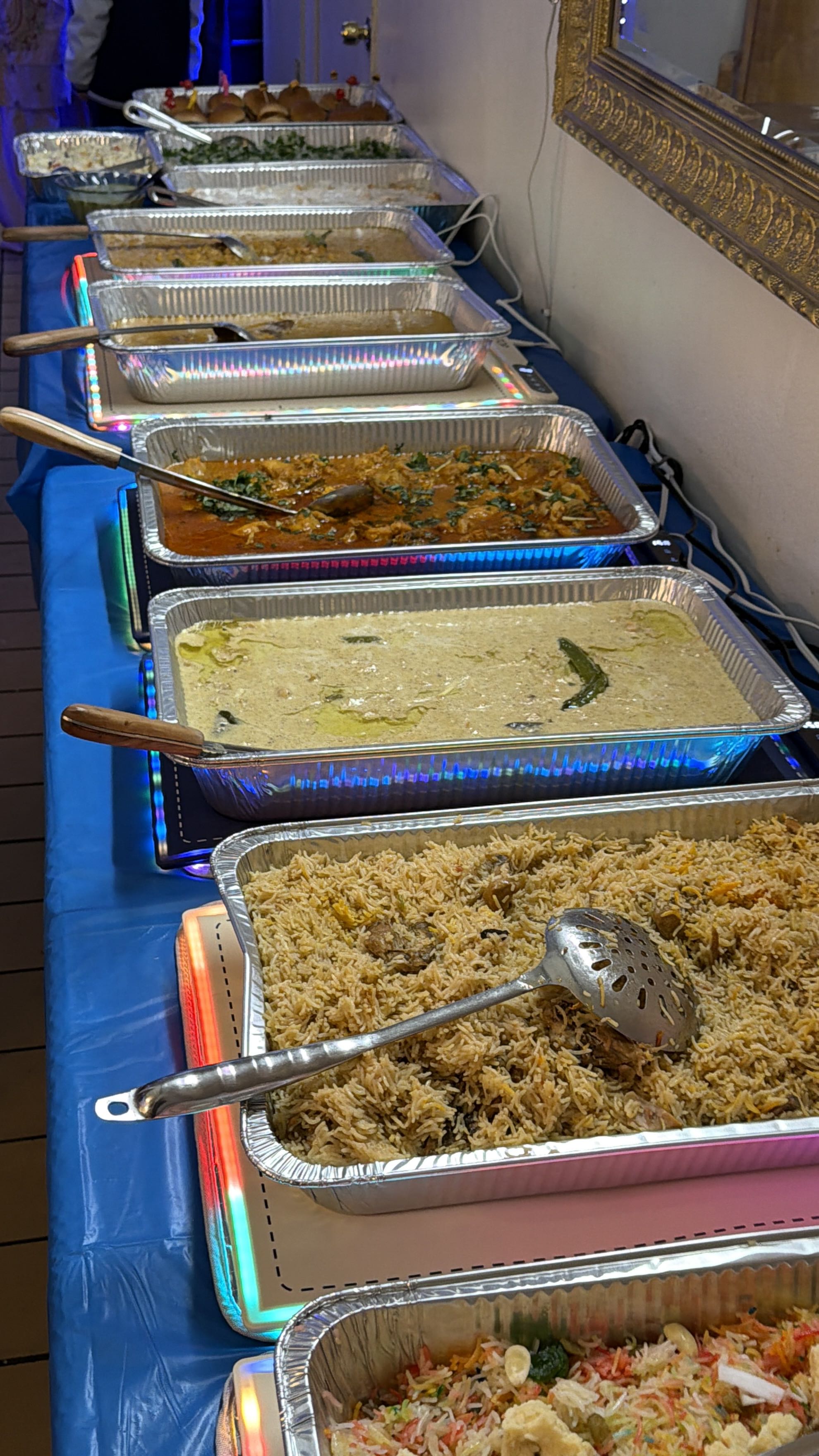 Pak Food catering buffet — biryani, curries, and wraps on steam tables